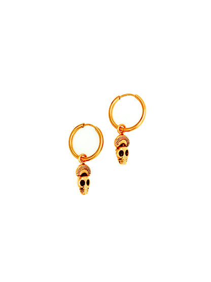 Gold skull earrings on a white background